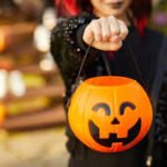 truco o trato una niña sujetando una calabaza de plastico para pedir caramelos niños pidiendo caramelos en halloween